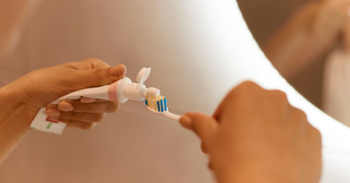 donna che mette dentifricio su spazzolino 