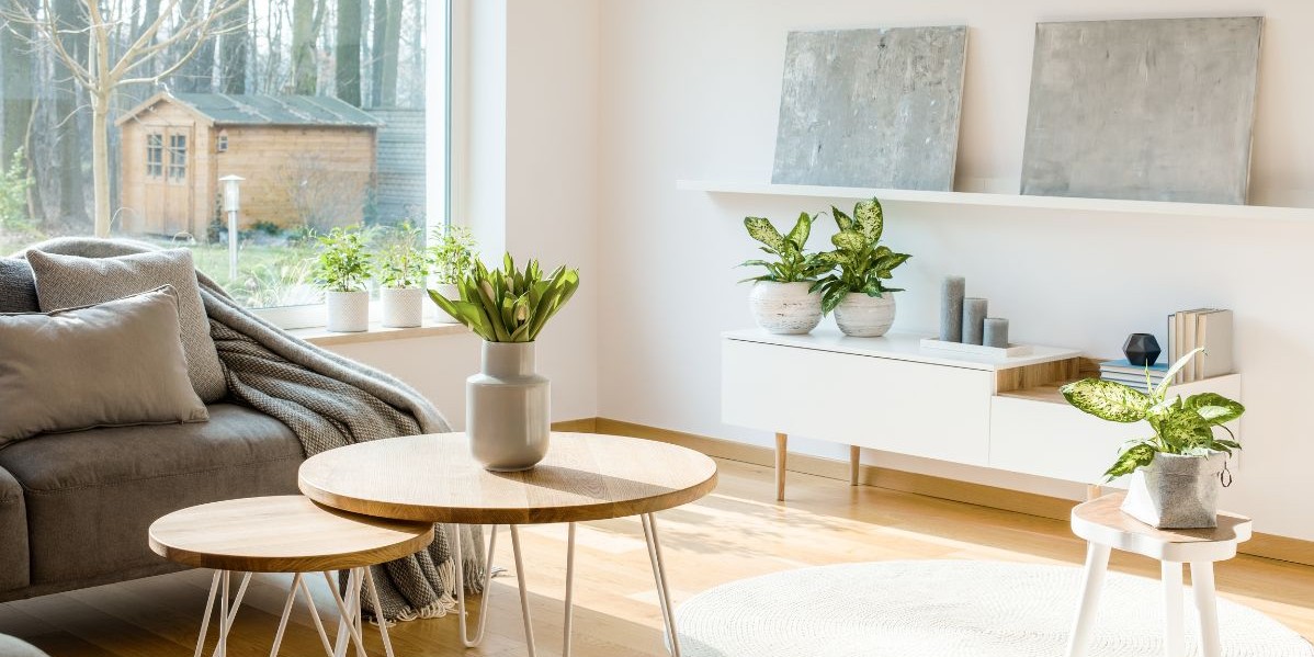 Interno di un soggiorno moderno e luminoso, con la luce del sole che filtra dalla finestra, a simboleggiare comfort termico e aria pulita, e un'atmosfera accogliente