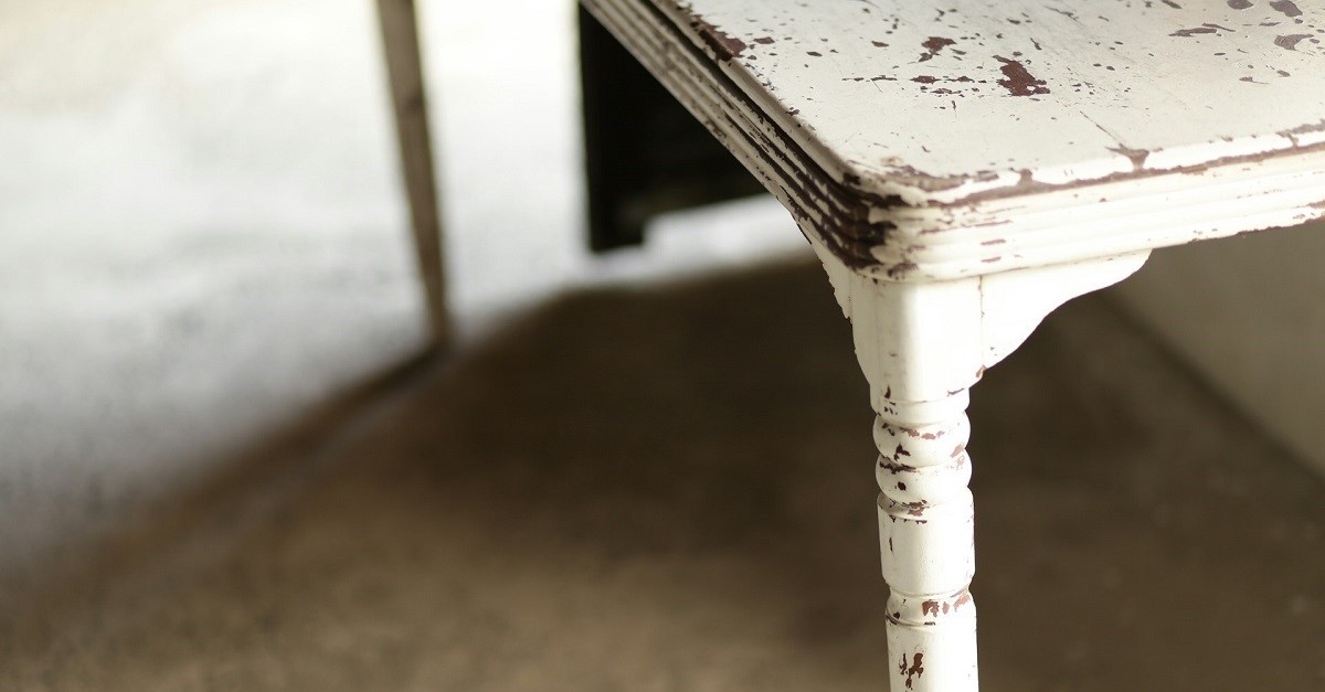 Un vecchio tavolo con le gambe rovinate