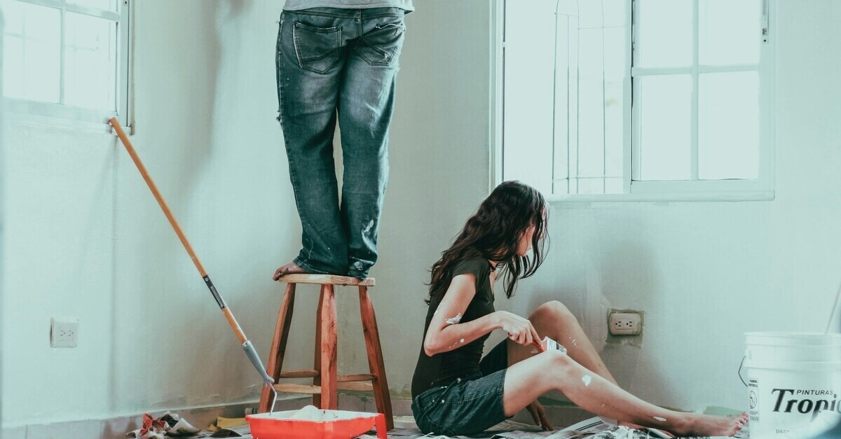 Una coppia rinfresca la parete di casa