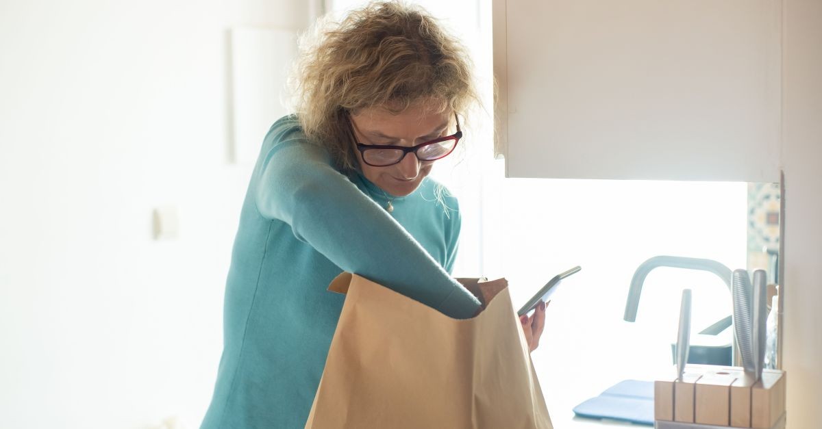 donna che piega busta di carta
