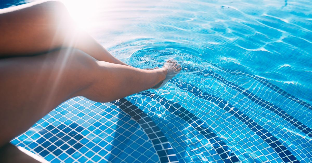 donna con gambe ammollo in piscina 
