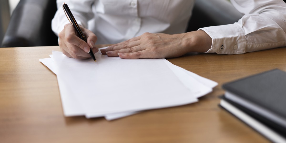 Mani di una professionista che firma un documento legale