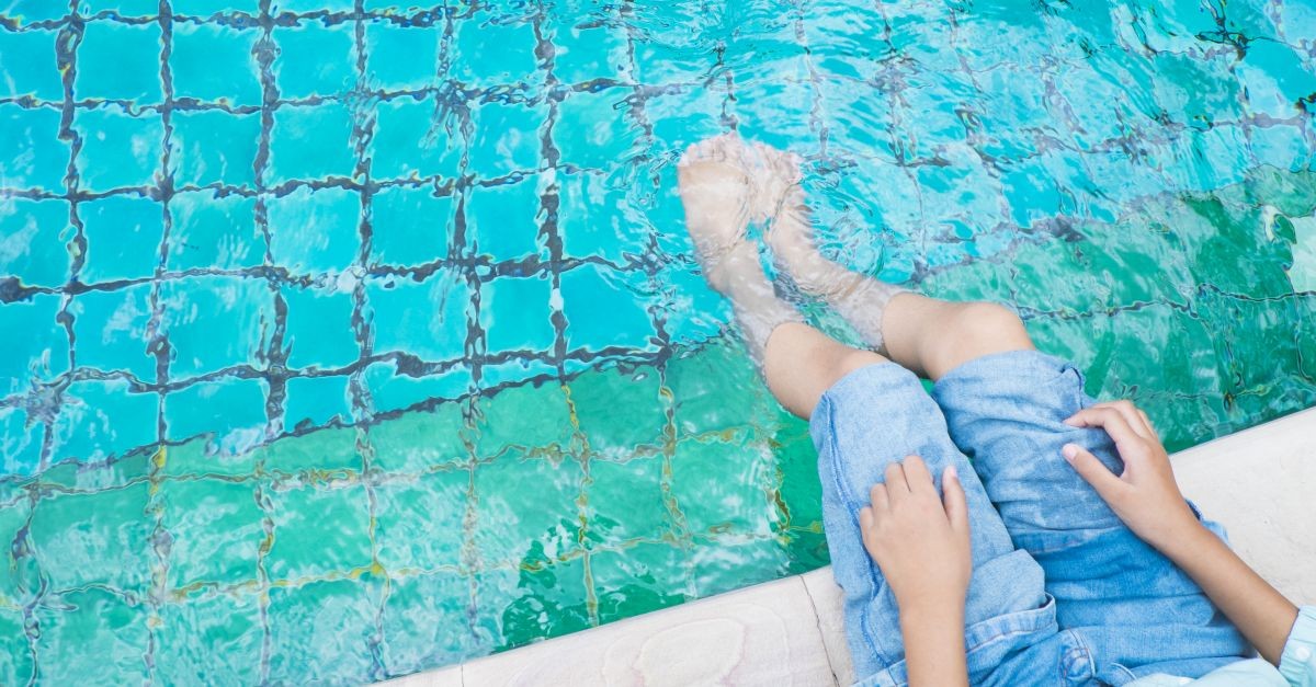 ragazza con piedi ammollo in piscina 