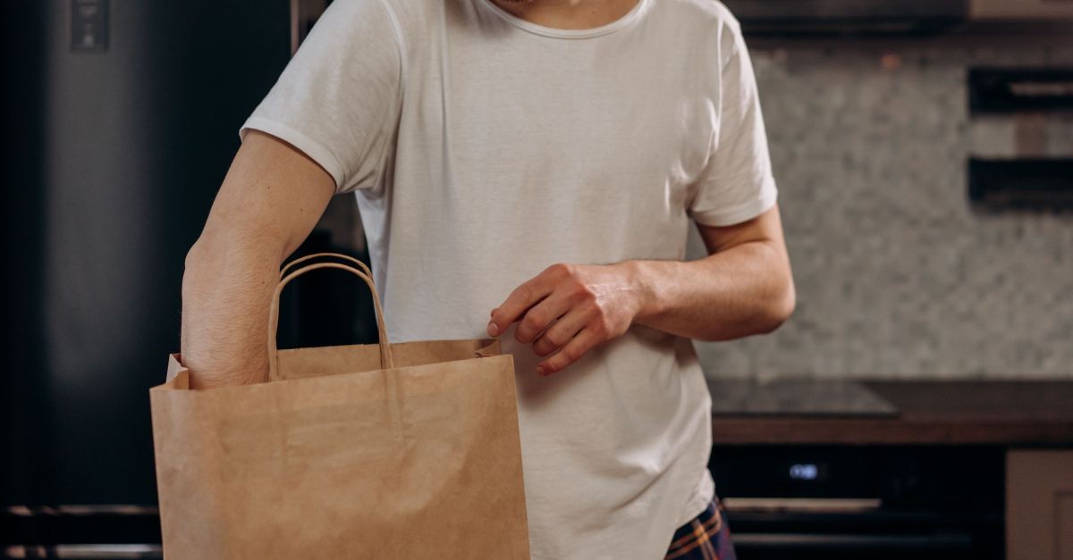 uomo davanti a sacchetto di carta 