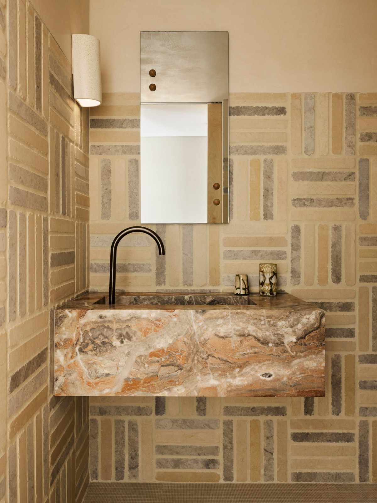 Uno dei bagni è caratterizzato da un lavabo sospeso in marmo Opus Rosso con venature ben visibili