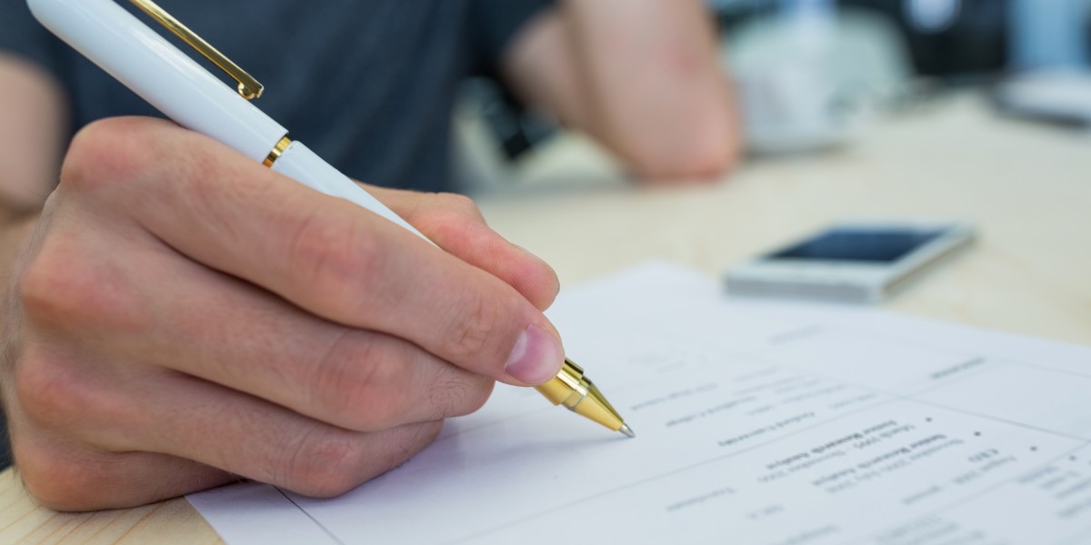 Mani che firmano un documento cartaceo su un tavolo