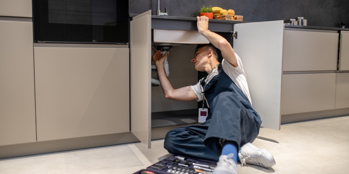 Uomo alle prese con riparazioni domestiche ispeziona un tubo sotto il lavello in cucina 
