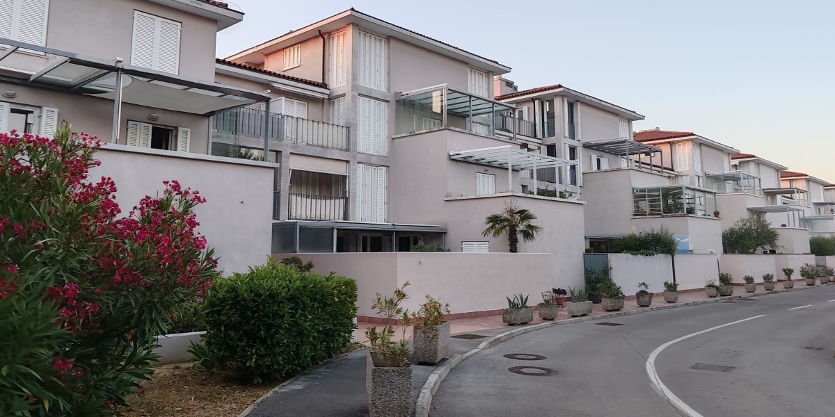 Complesso residenziale contemporaneo con aree verdi esterne illuminate al crepuscolo