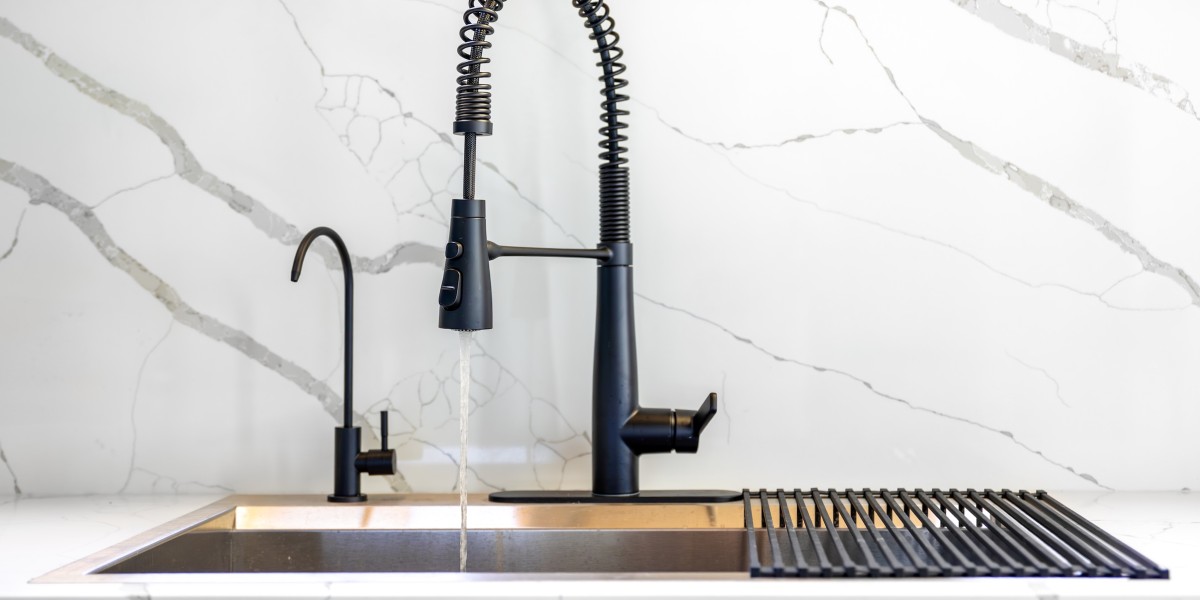 Rubinetto con acqua corrente in una cucina in acciaio inox