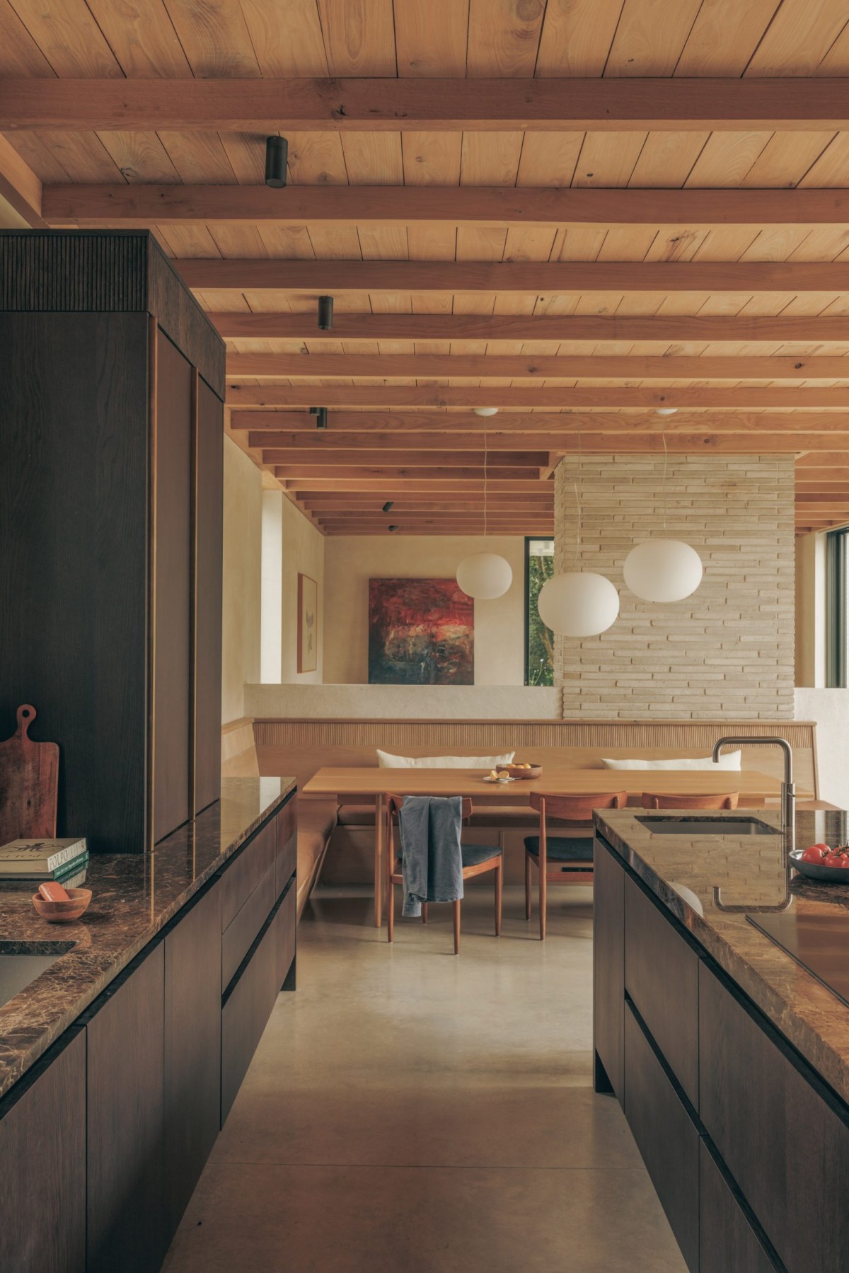 Muebles de madera oscura se funden con las encimeras de mármol marrón veteado.