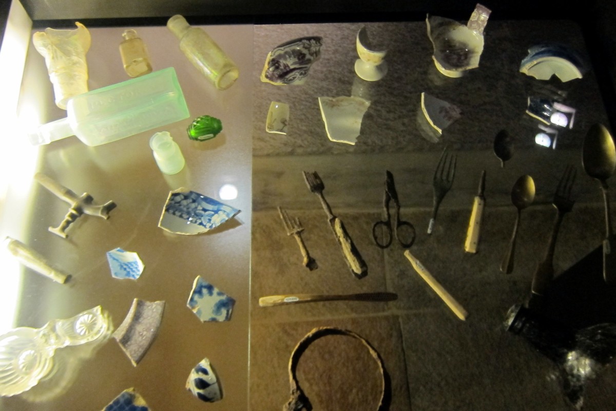 Stoviglie, posate, forbici e bottiglie di vetro in ceramica o porcellana rinvenute durante gli scavi