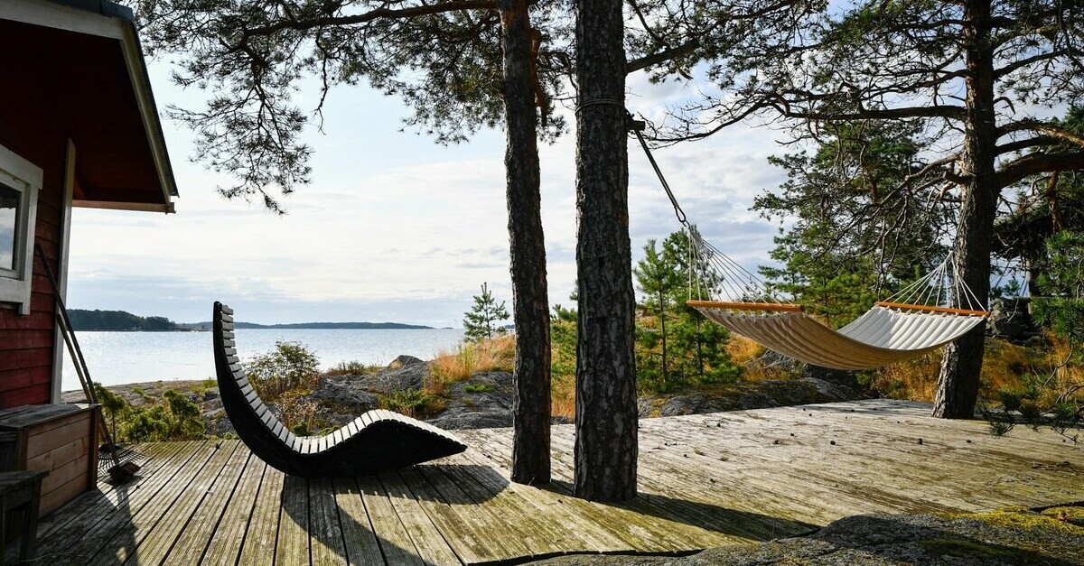 Un prato verde ed una sdraio in legno di fronte al mare finlandese