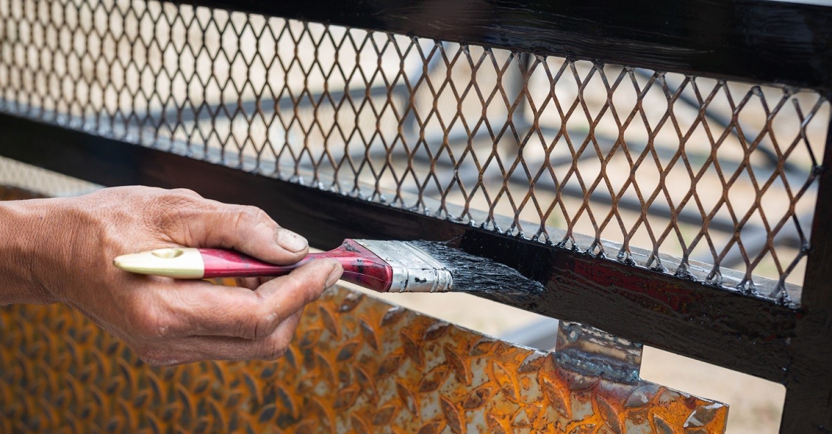 Uomo al lavoro su un balcone in ferro