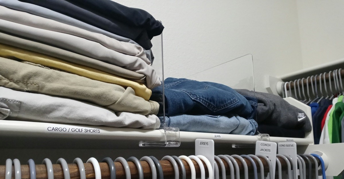 Pile di abiti su una mensola con separatori verticali