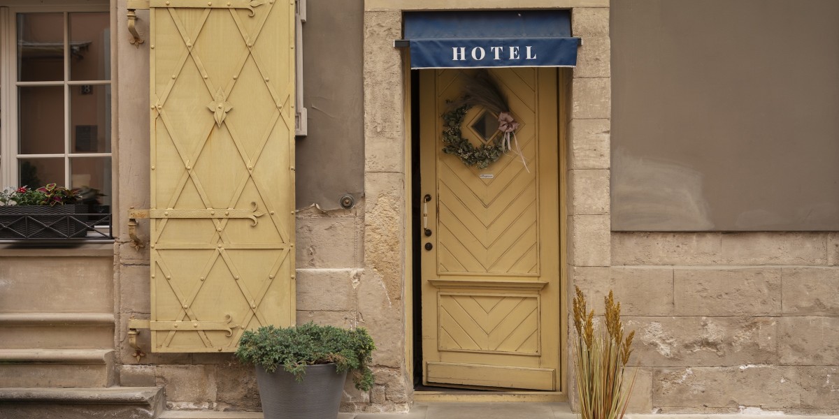 Facciata signorile di un condominio italiano storico con dettaglio del portone d'ingresso e pulsantiera in ottone, idonea a rappresentare il contesto condominiale