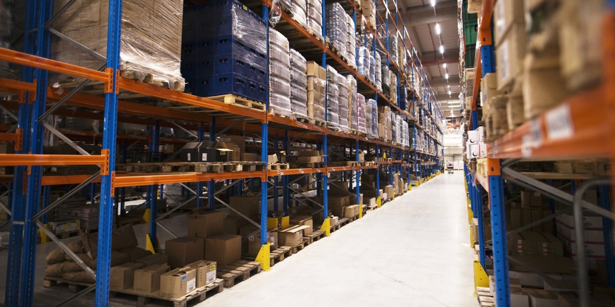 Interno di un grande magazzino di distribuzione, con scaffali colmi di pallet e merci pronte per il mercato