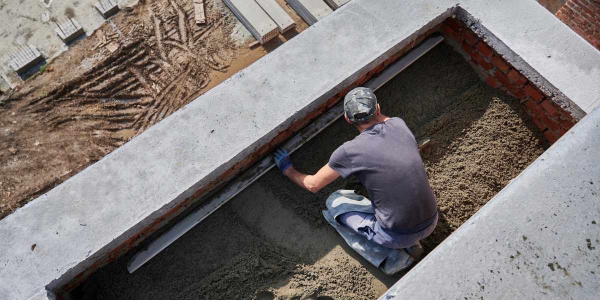 Operaio che stende il massetto in un cantiere edile