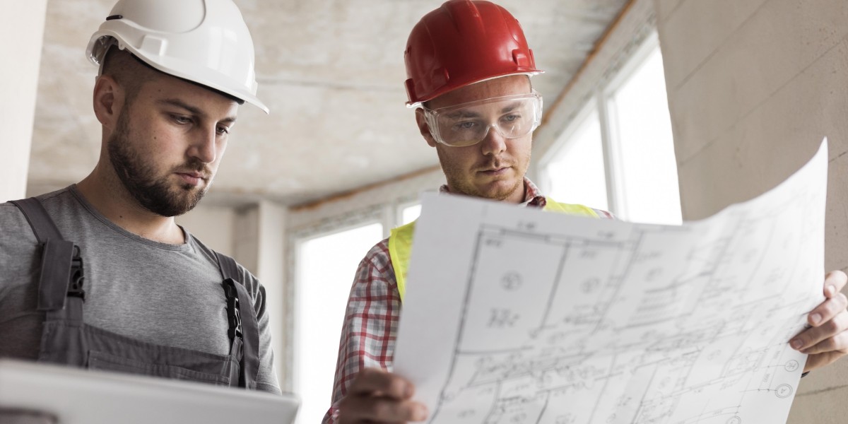 Professionisti con casco protettivo e tavole di progetto edilizio intenti a verificare lo stato dei luoghi in un cantiere di ristrutturazione residenziale