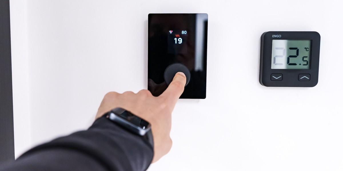 Una mano che regola un termostato digitale in un interno di casa moderna, che mette in mostra la tecnologia della casa intelligente.