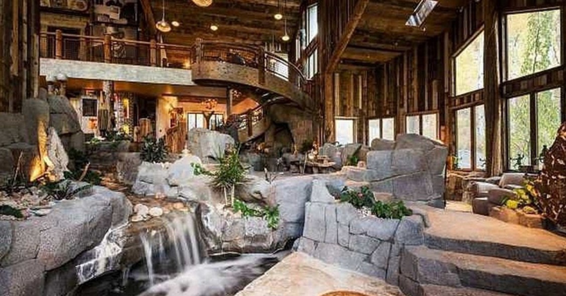 Una casa di montagna che passerebbe inosservata se non fosse per il fiume che attraversa il salone (Fotogallery)