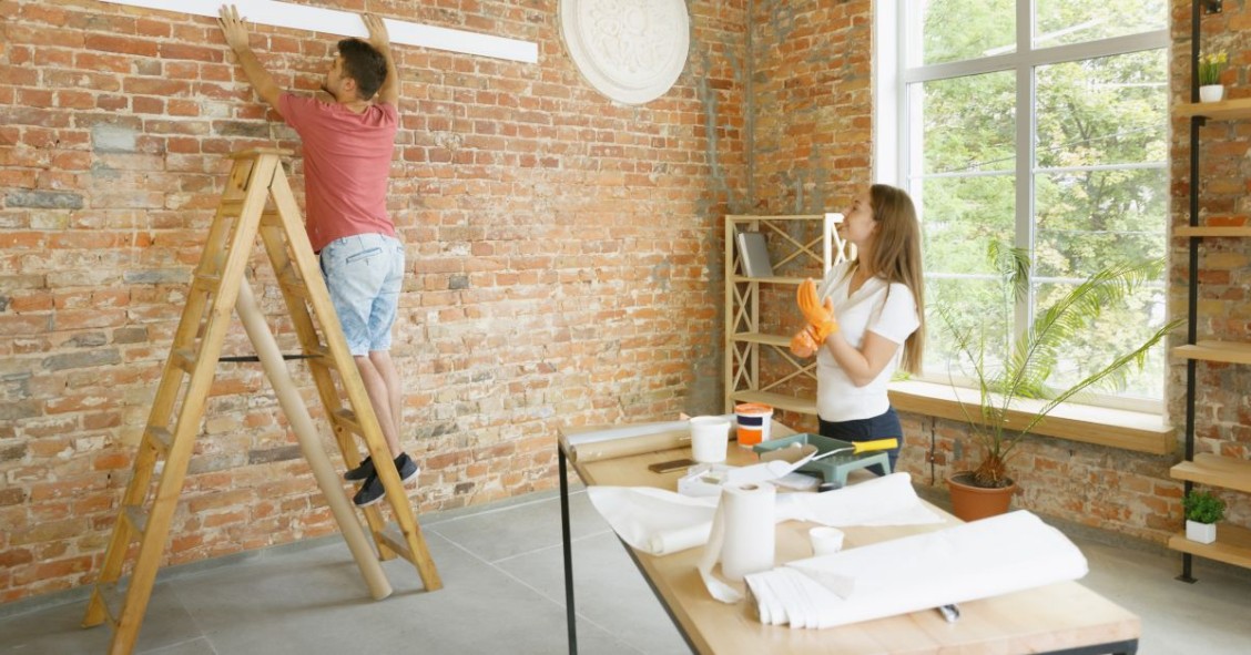 Pareja joven trabajando en un muro