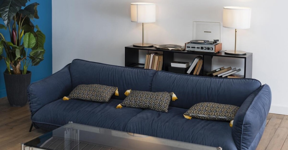 divano blu con mobile dietro