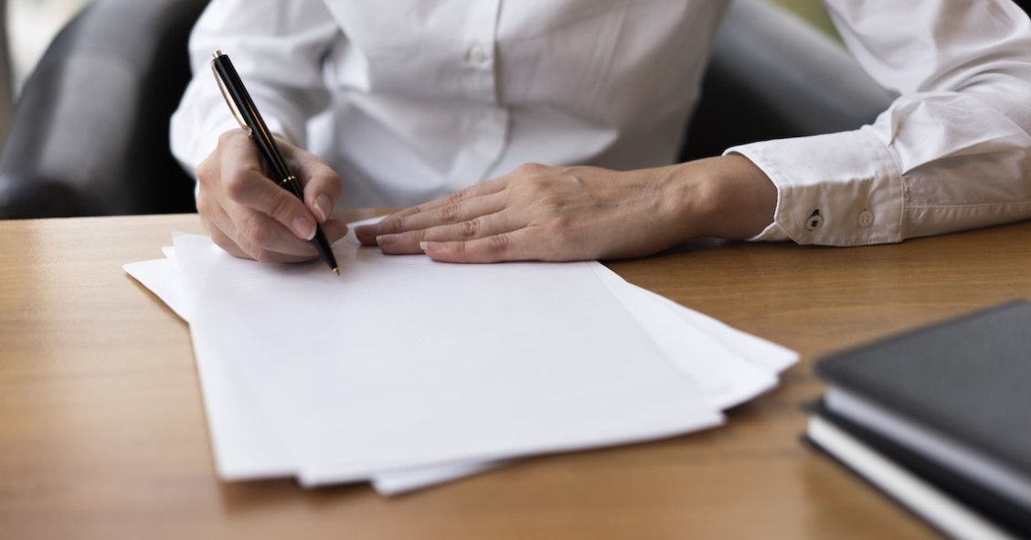 Donna concentrata a firmare un documento