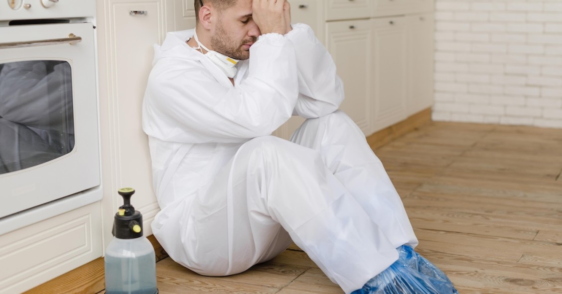 Uomo seduto sul pavimento della cucina
