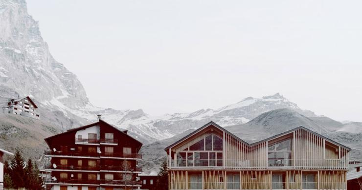 Uno chalet in legno prefabbricato che imita le montagne con i suoi tetti irregolari