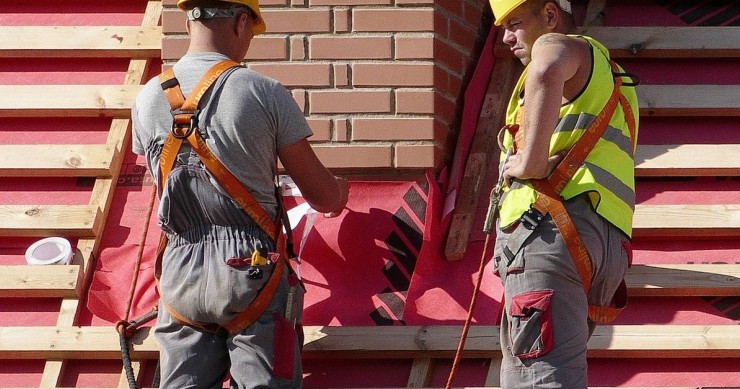 Due operai lavorano sul tetto di un'abitazione per inserire il cappotto termico