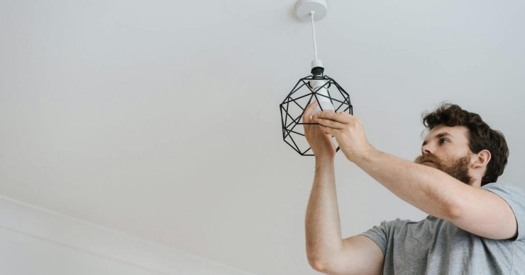 uomo monta lampadina per luce elettrica