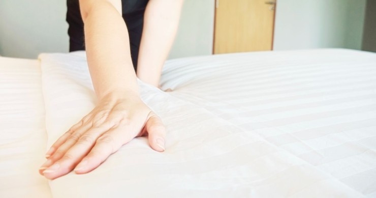 donna che sistema il letto