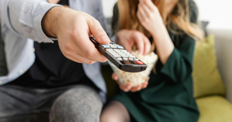 una persona usa il telecomando tv