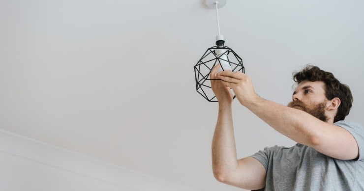 uomo che cambia una lampadina