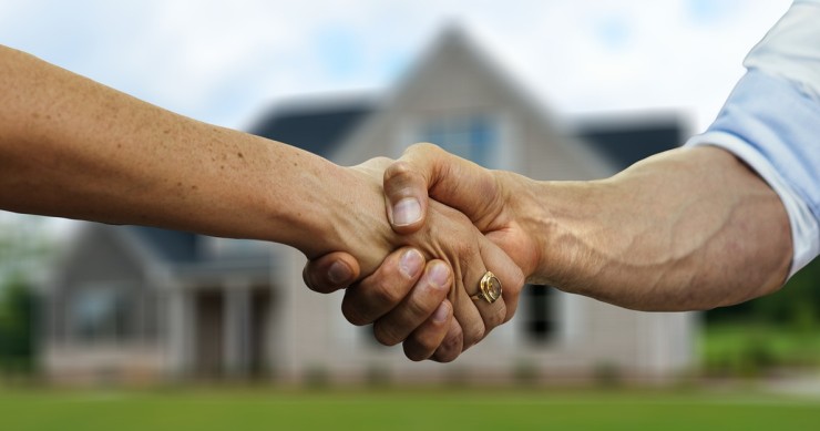 Persona che firma un contratto per l'acquisto di una casa, simbolo di transazioni immobiliari, ideale per chi sta considerando la vendita di un immobile proveniente da donazione, con riferimento a processi legali e fiscali legati all'acquisto e alla cessione di una proprietà.