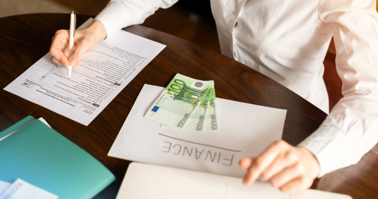 donna che lavora con le finanze sul tavolo soldi documenti