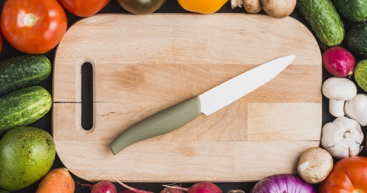 coltello in ceramica su tagliere con verdure