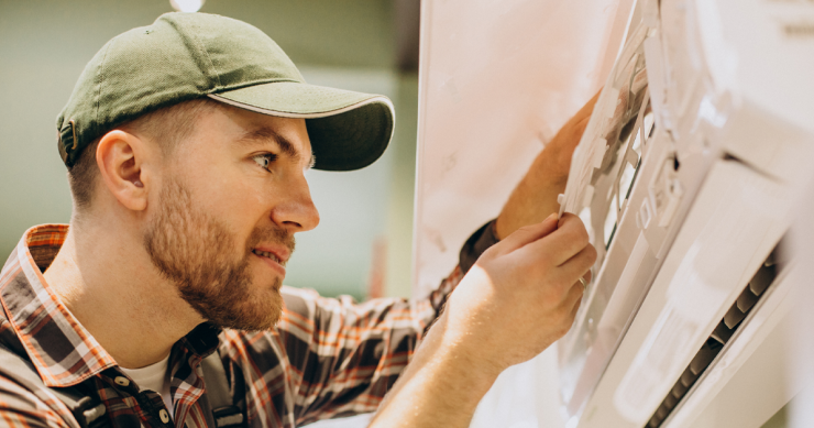 un uomo interviene su un condizionatore