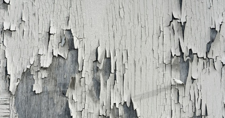 Una parete di legno con vernice che si stacca