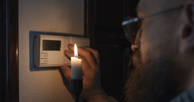 uomo che spegne il termostato al buio