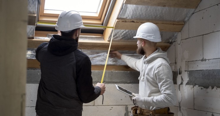Due operai lavorano alla realizzazione di un cappotto termico