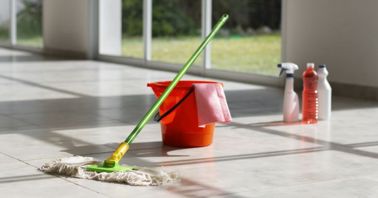 secchio su un pavimento con prodotti per pulire