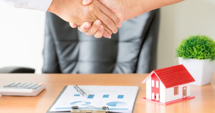 Agente-cliente, stretta di mano dopo contratto firmato per l’acquisto di un nuovo appartamento