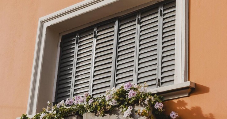 Persiane in legno con vaso di fiori