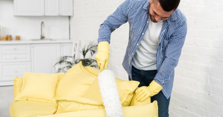 Divano giallo spolverato con un piumino