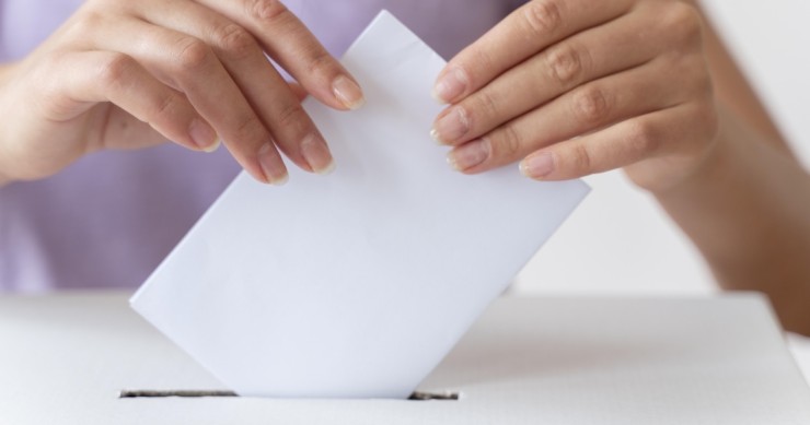 Persona che colloca la propria scheda elettorale nell’urna