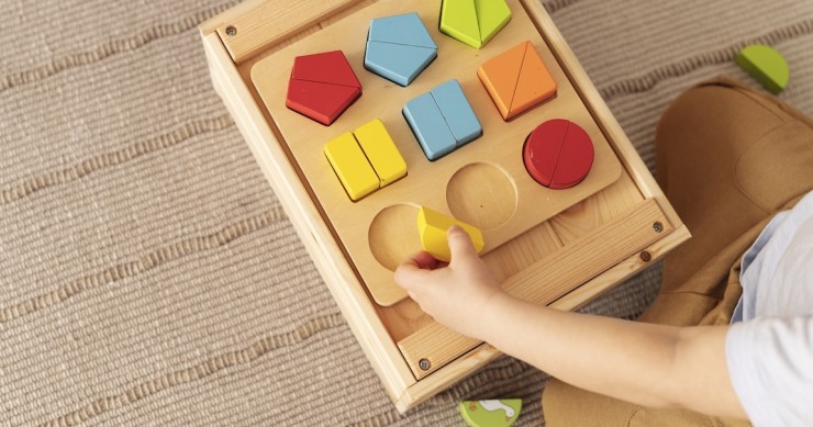 Bambino che gioca con un giocattolo di legno