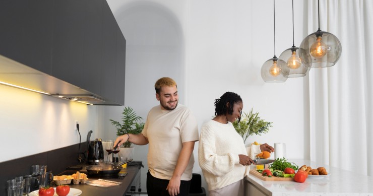Una coppia in una cucina con lampadari a sospensione