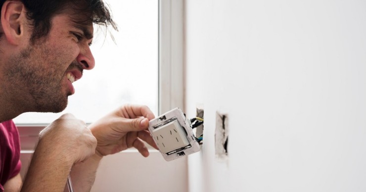 Uomo lavora su un impianto elettrico domestico